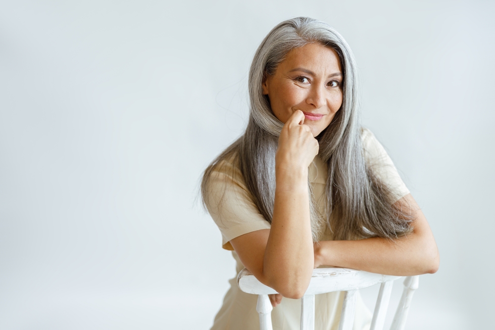 Flirting,Middle,Aged,Asian,Lady,With,Beautiful,Grey,Hair,Sits