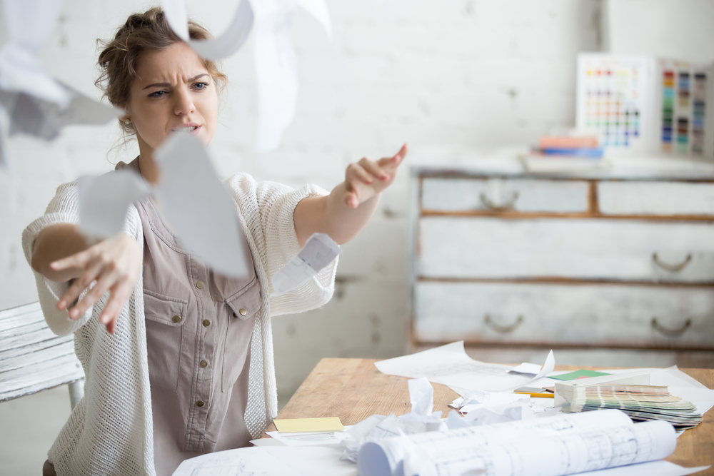 Young,Stressed,Woman,Sitting,At,Desk,In,A,Little,Office