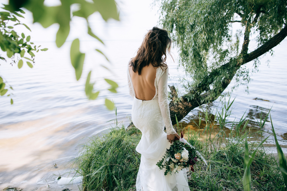 Bride,In,A,White,Dress,Walking,In,The,Woods,By