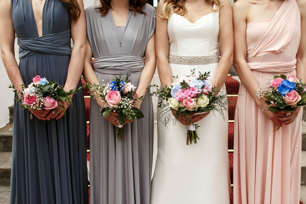 Bride,And,Bridesmaids,In,Pastel,Dresses,Stand,In,A,Ray
