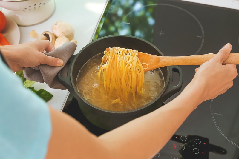 Woman,Cooking,Pasta,On,Electric,Stove