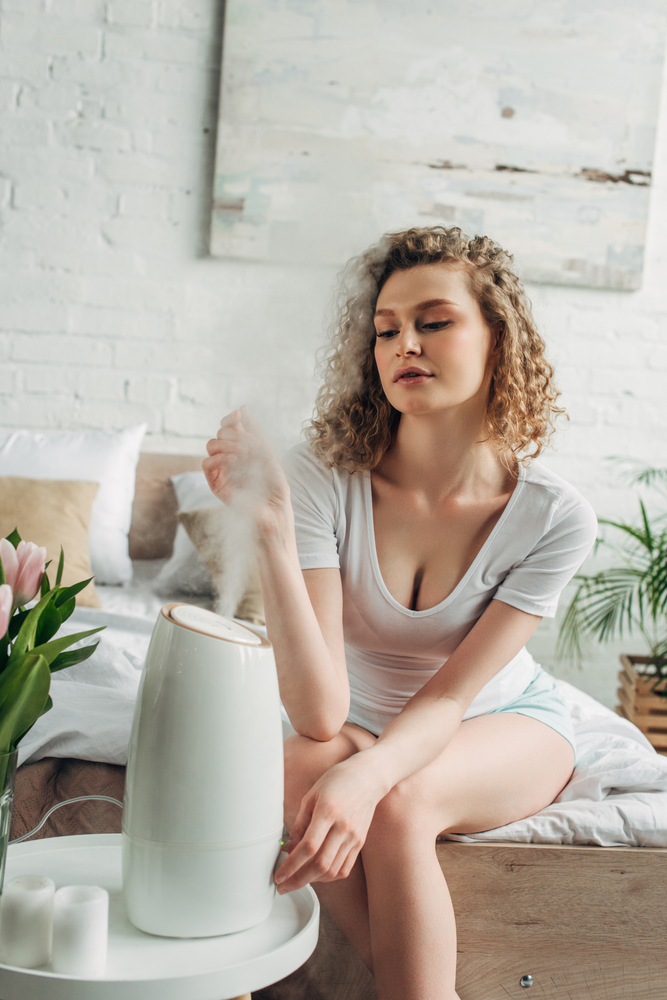 Attractive,Girl,Sitting,In,Bedroom,With,Air,Purifier,And,Tulip